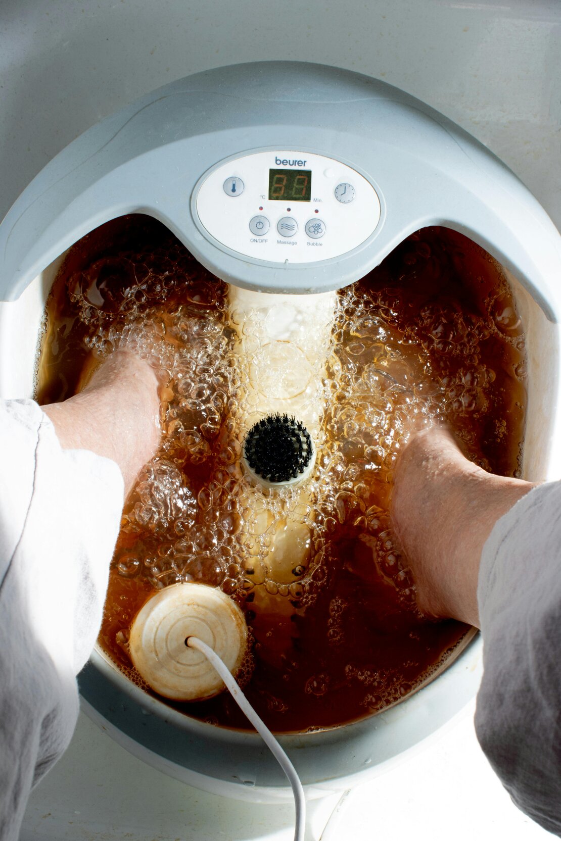 Feet soaking in an ionic foot detox bath at a spa