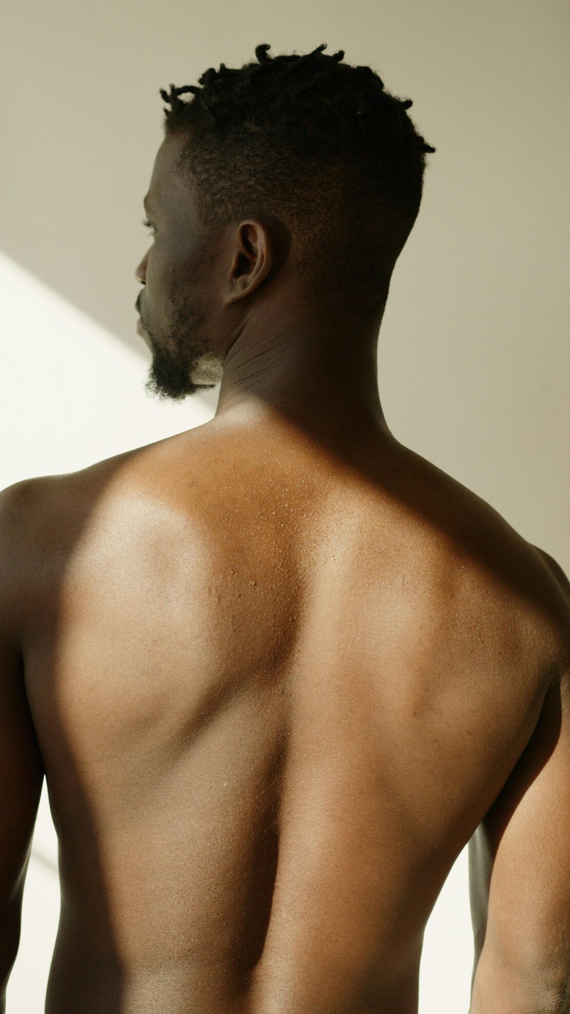 Therapist waxing a male client’s back in a clinic