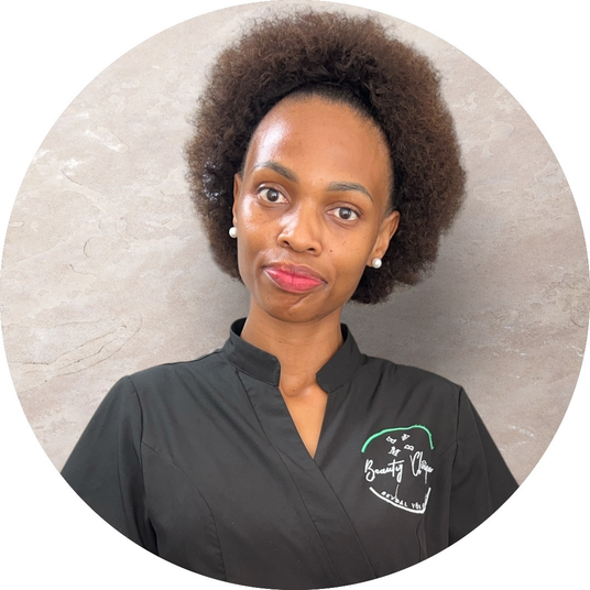 Professional beauty therapist in clinic uniform smiling at the camera
