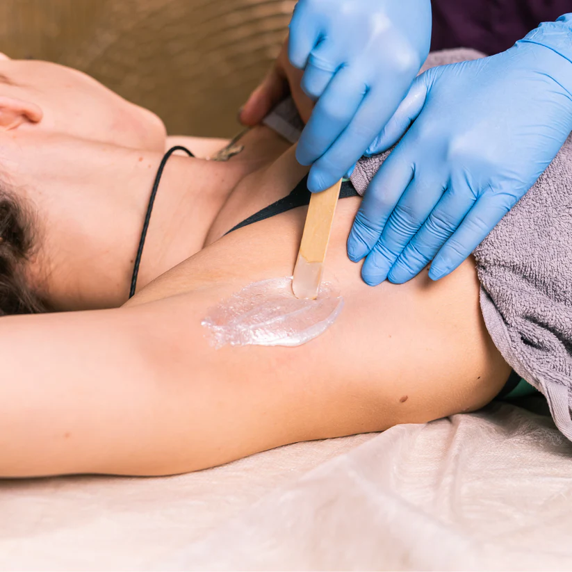 Therapist preparing waxing treatment on a client